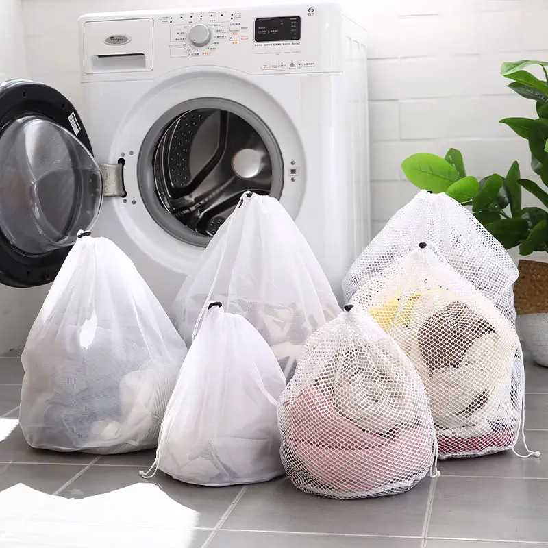 Organized collection of mesh and heavy-duty laundry bags sorted by size, color, and fabric type for household and commercial use